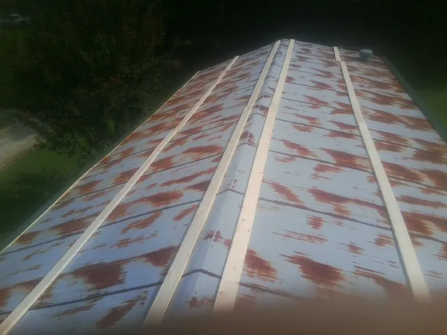Rusted metal roof panels with new wood purlins before replacement — Storm Damage Roof Repair in Fairview Heights by Roofing Brothers