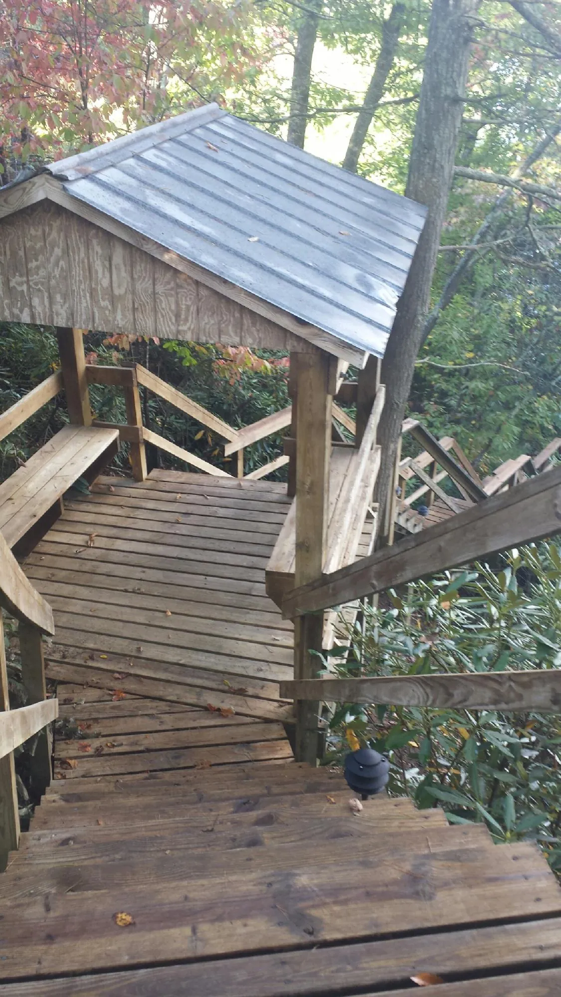 Metal roofed shelter over wooden steps on a wooded walkway — Skylight Repair & Installation work by our crew in Fairview Heights